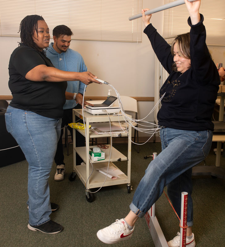 Koyya evaluating a student during exercise.