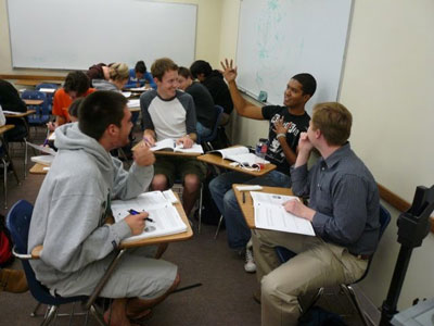 Students grouped up in a circle, discussing