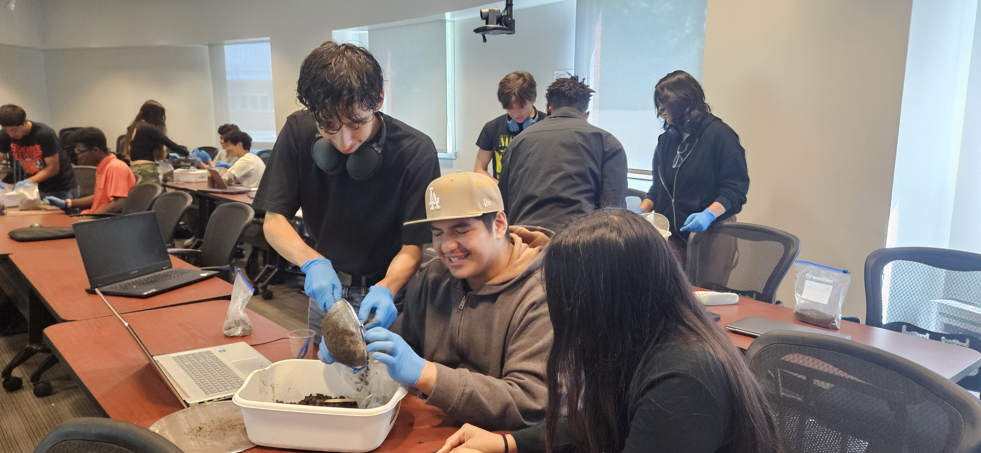 SCI1100 students looking through soil samples in a classroom