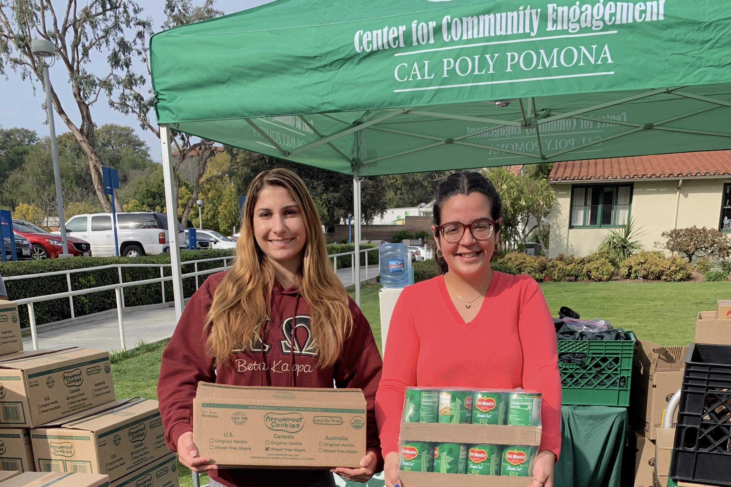 Members of a sorority hold up food donations