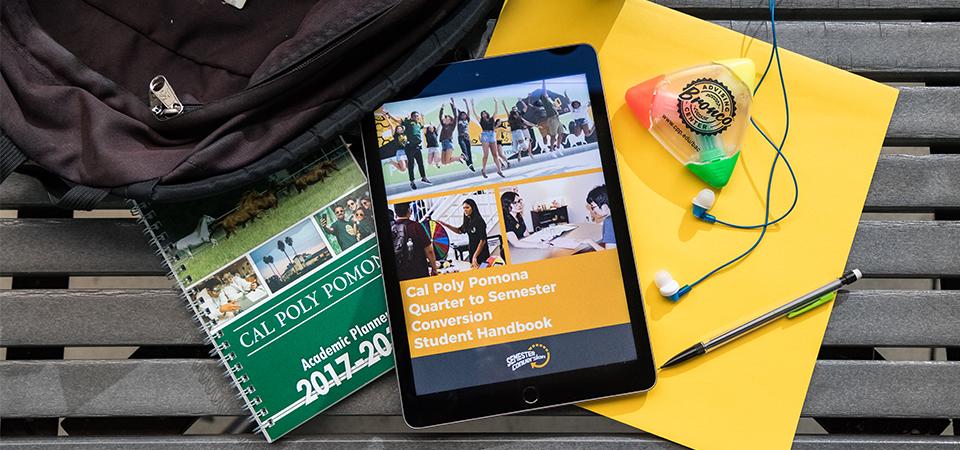 An iPad displaying the handbook, surrounded by study materials. 