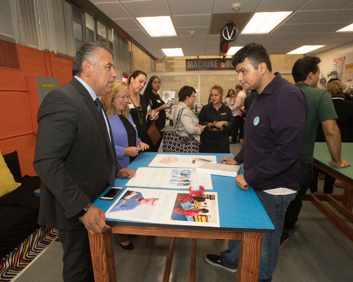 visitors learning about IO equipment from student