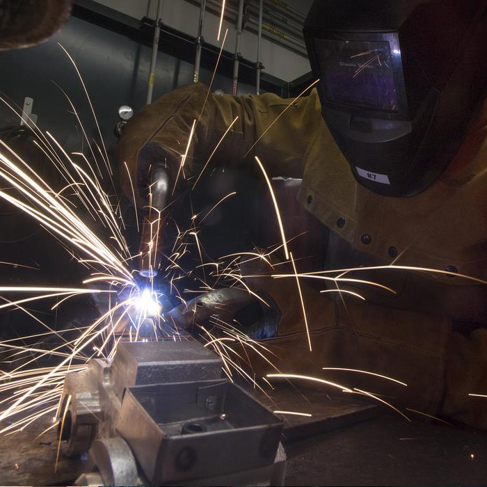 A mechanical engineering senior makes a mig weld during his Manufacturing Process lab