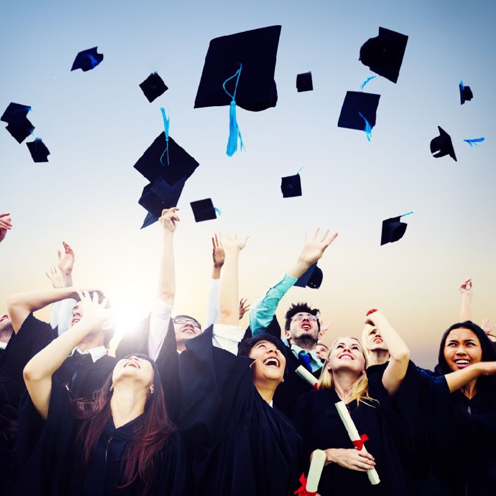 graduation students throwing caps in the air