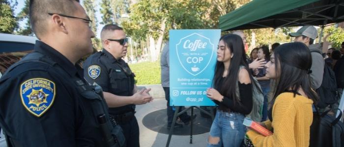 Students speak with officers at a Coffee with a Cop event