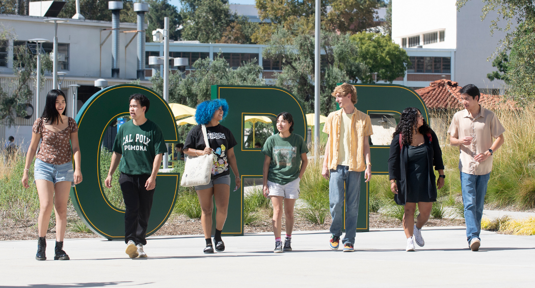 Students walking in front of the CPP letters