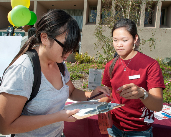 A student fills out a clipboard at a table