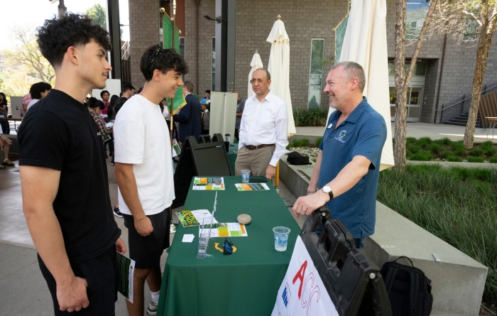 Students interact with people at a booth