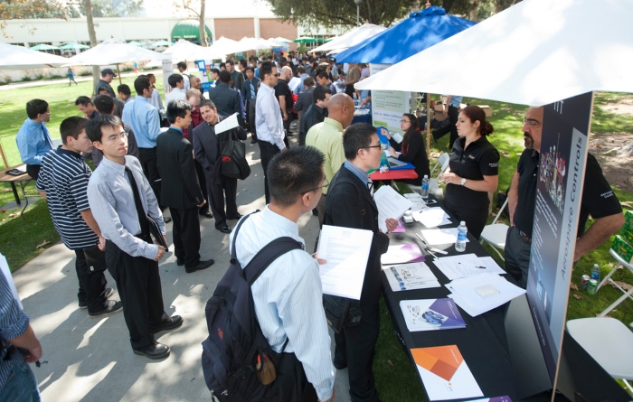Students interact with people at a booth