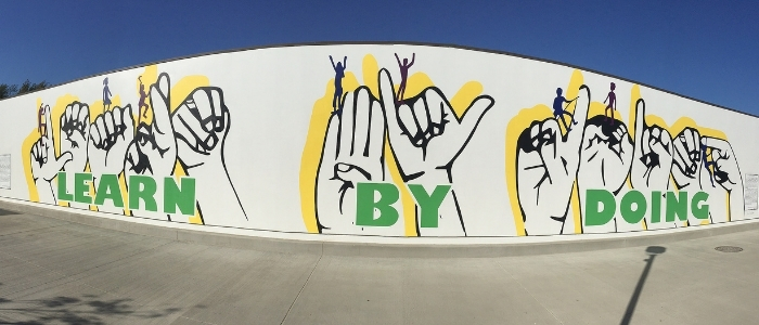 'Learn by Doing' Mural on campus using sign language