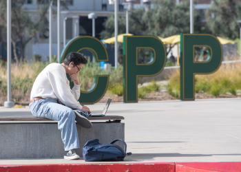 A student checks his laptop on campus