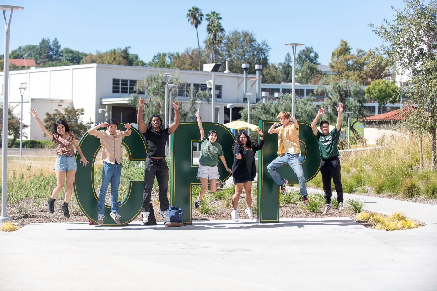 Diverse group of Cal Poly Pomona students posing near CPP sign