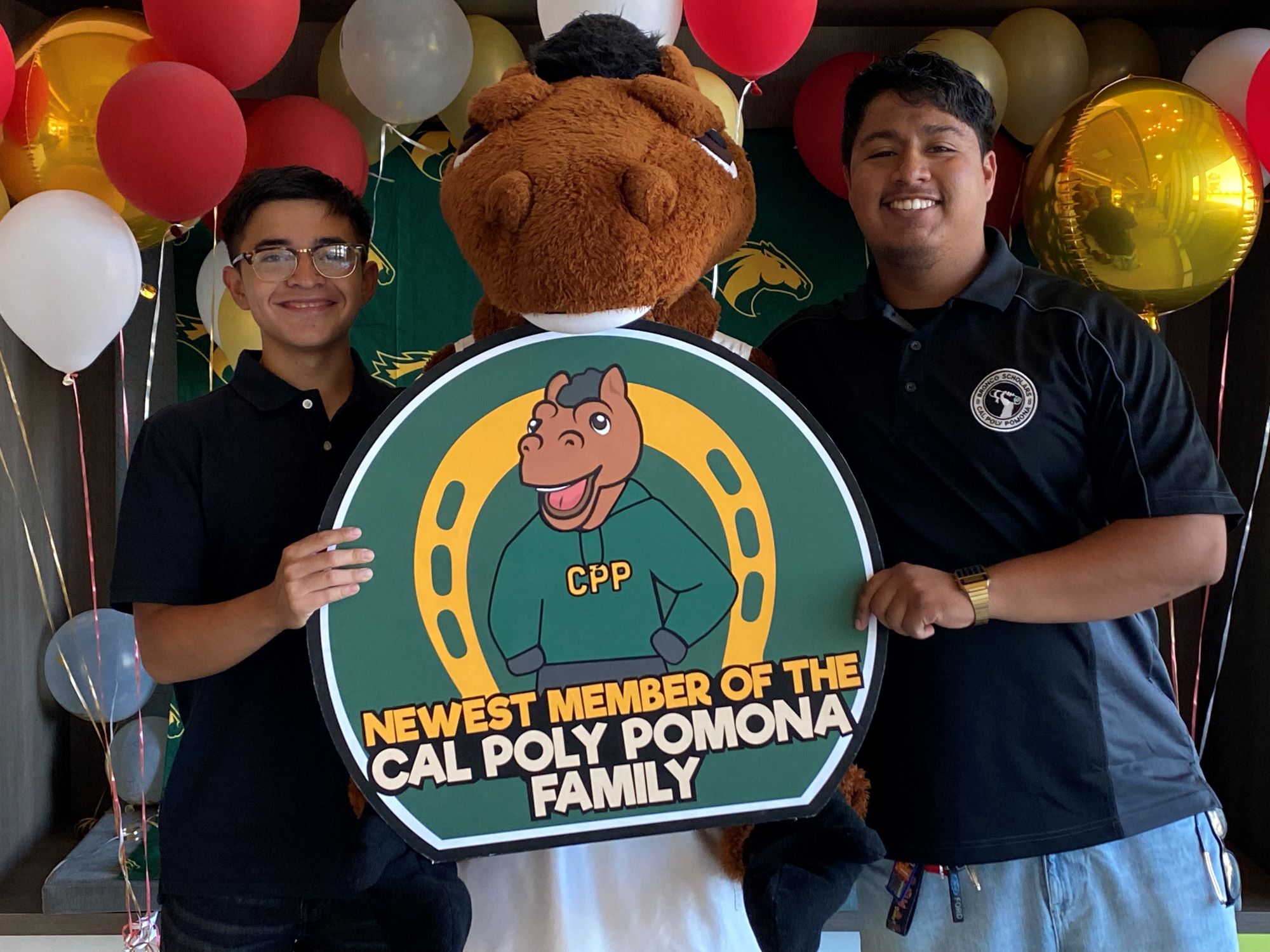 Two students with Billy holding sign