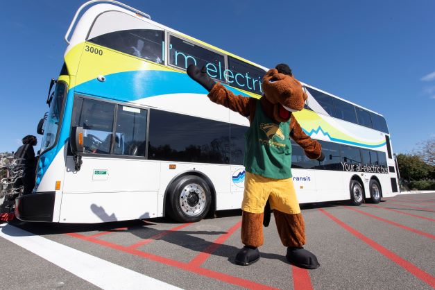Billy stands in front of a foothill transit bus