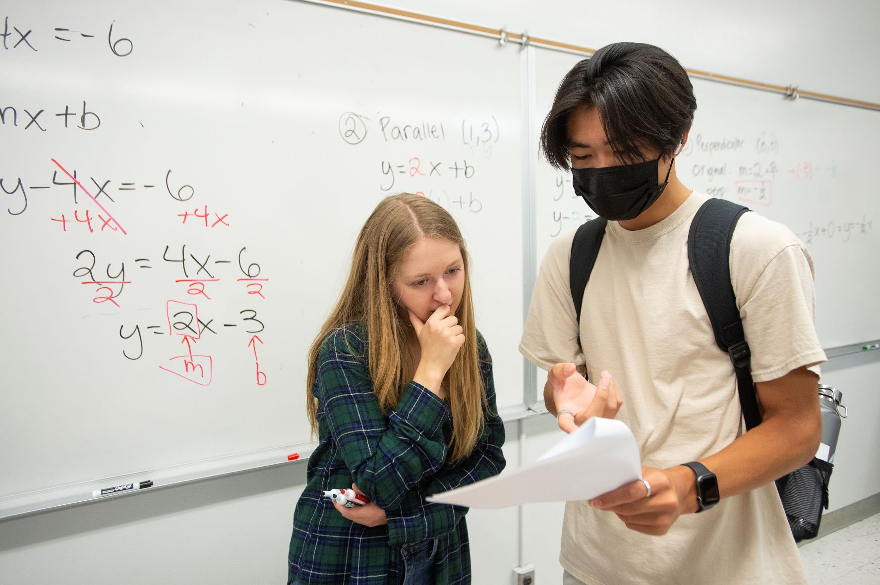 A tutor and student work together in a math class
