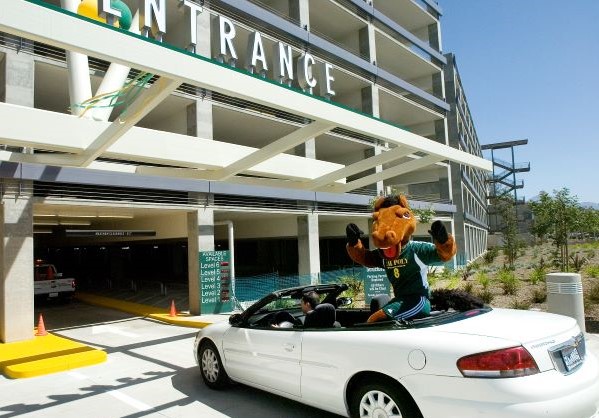 Billy Bronco waving from a convertible driving into Parking Structure I 