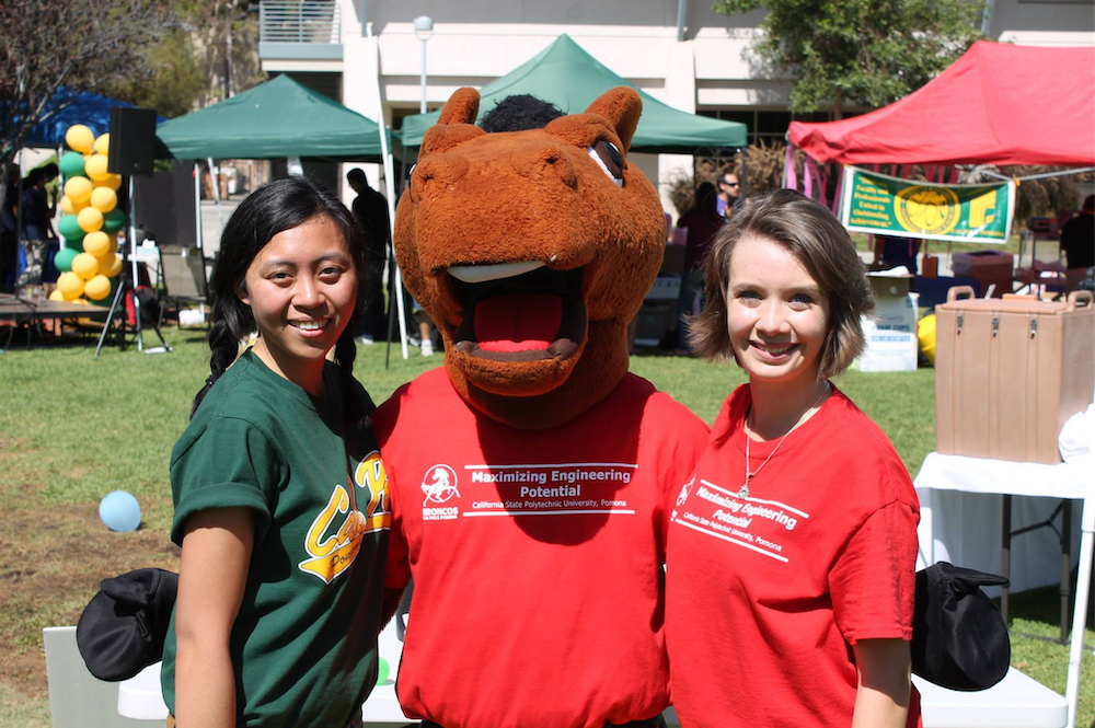 A pair of female students pose with Billy Bronco at an outdoor event