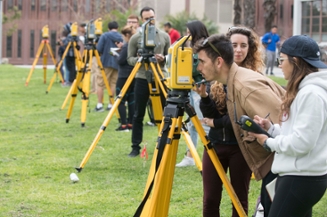 A class of civil engineering students surveying buildings