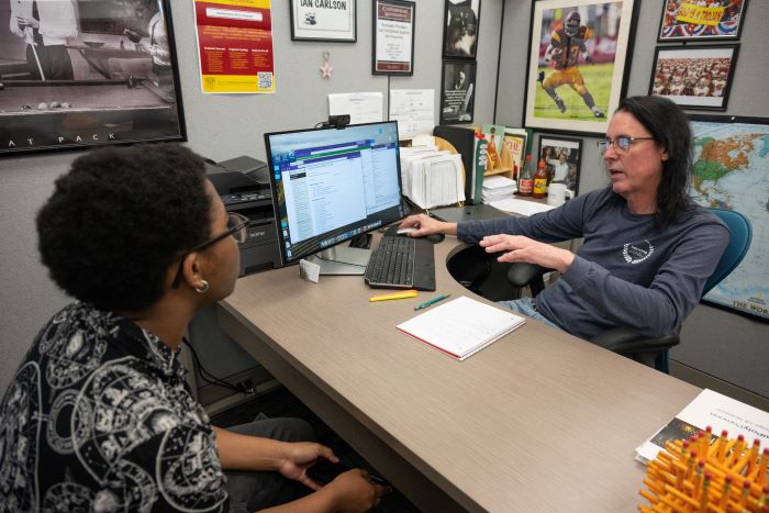 A student talks to an advisor in their office
