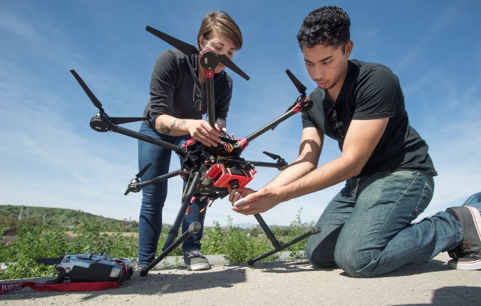 Two students work together on a drone