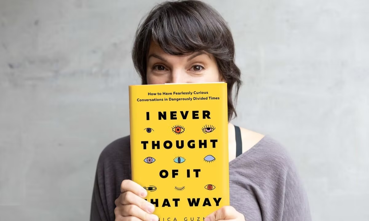 Mónica Guzmán holding her book I Never Thought of It That Way up against her face