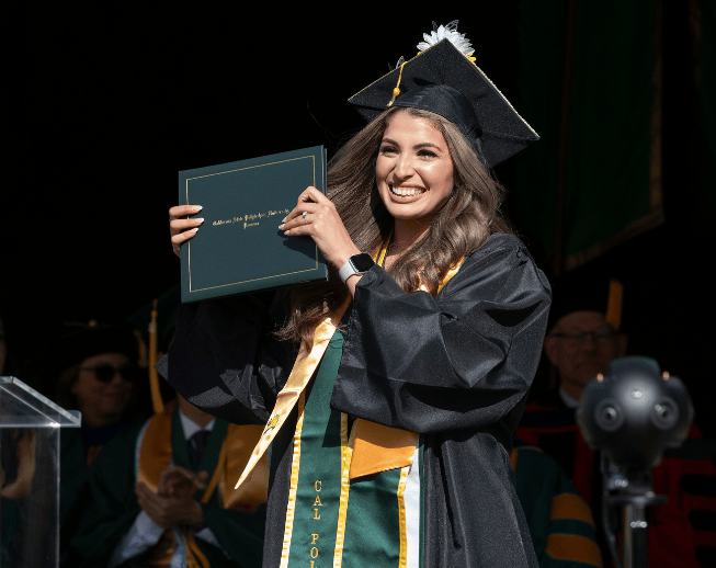 Graduate cheering with diploma in hand.
