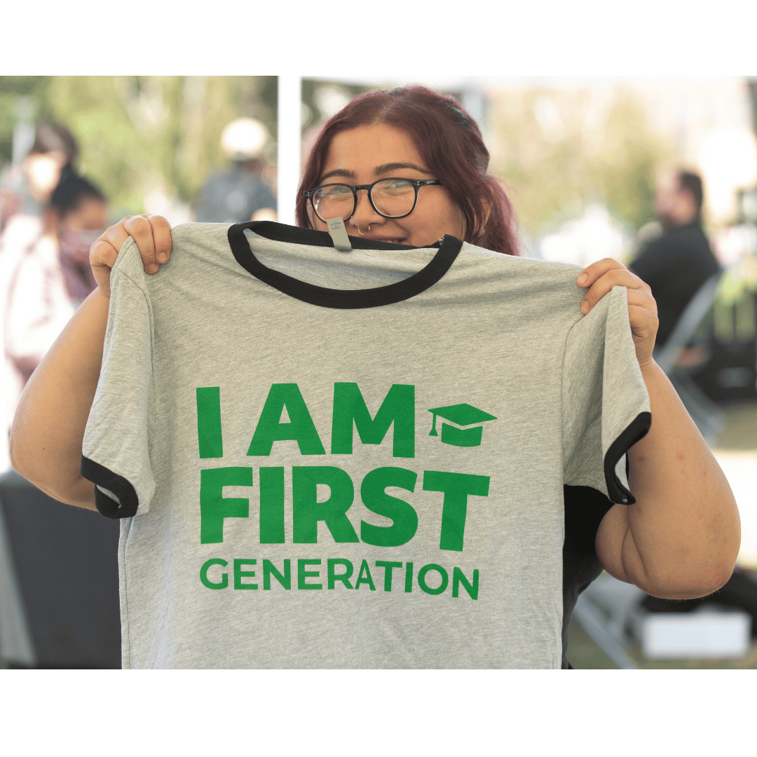Student holding I Am First Shirt
