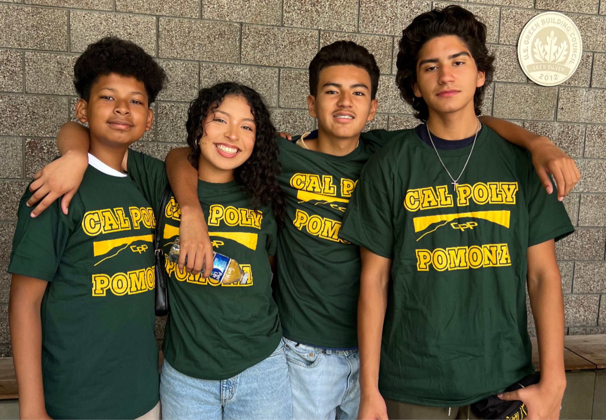 A male and female student stand together at Homecoming. Both are decked out in CPP gear and face painting