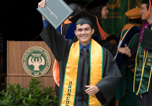 Student at Commencement holds up degree