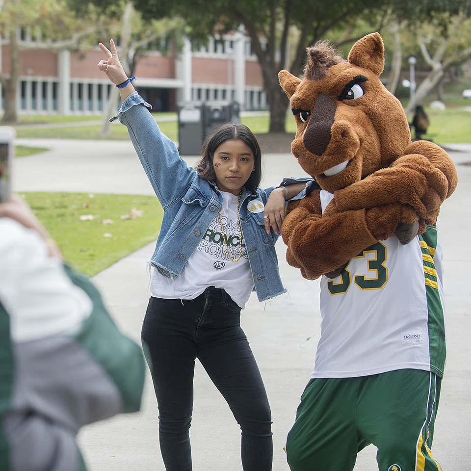 Student standing with Billy Bronco