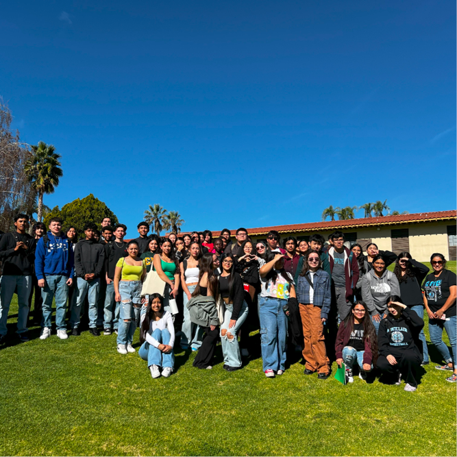 Students pose in a group in front of the old stables