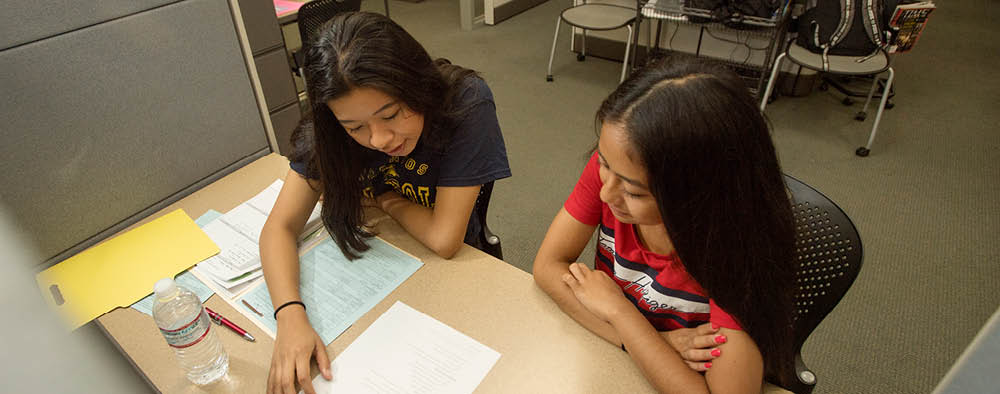 Two female students work on homework together in the Learning Resource Center