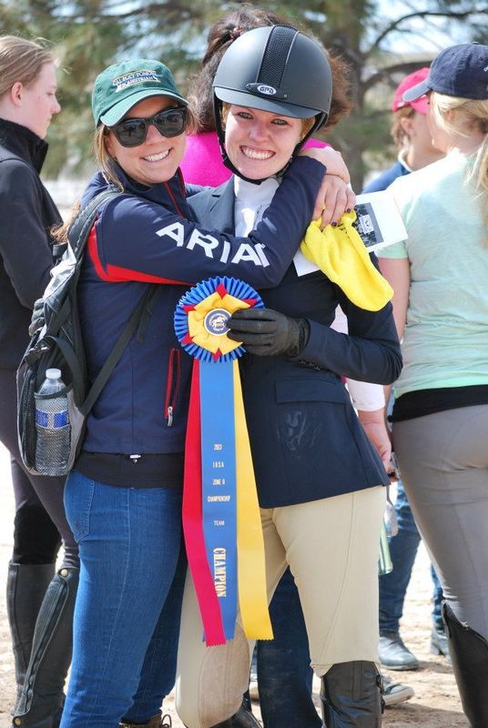 a woman hugs another woman colleague holding badge