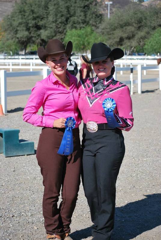 two women hold winning badges