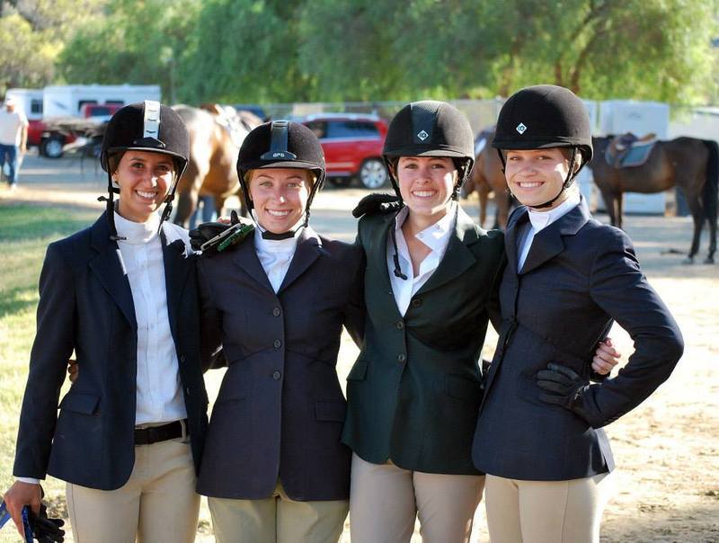 four equestrian woman smile for the camera