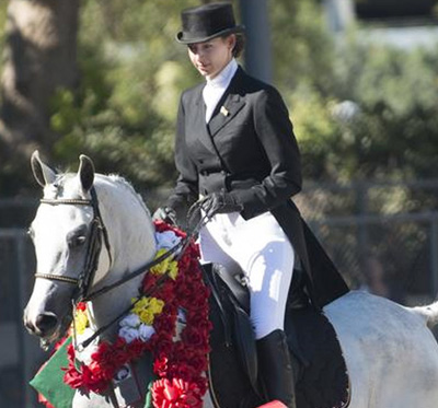 icon of female equestrian on white horse with flower leis