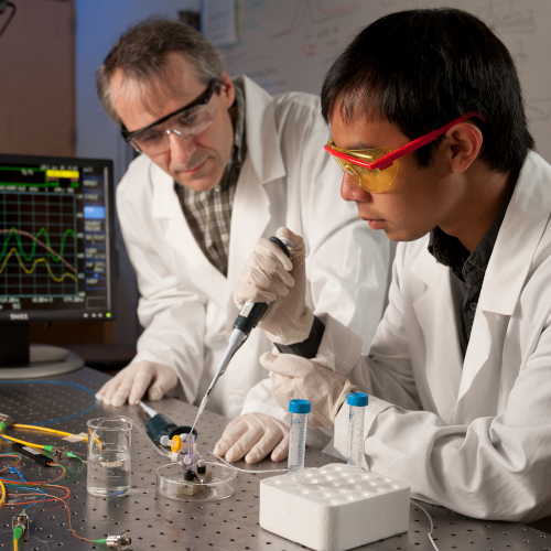 Professional Growth - mentor observing his student during a lab experiment