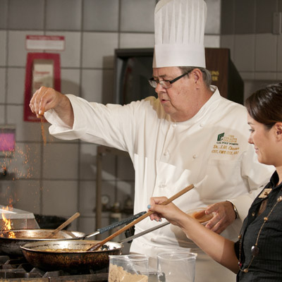 Professor working with student cooking