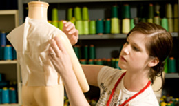 student pinning fabric on mannequin
