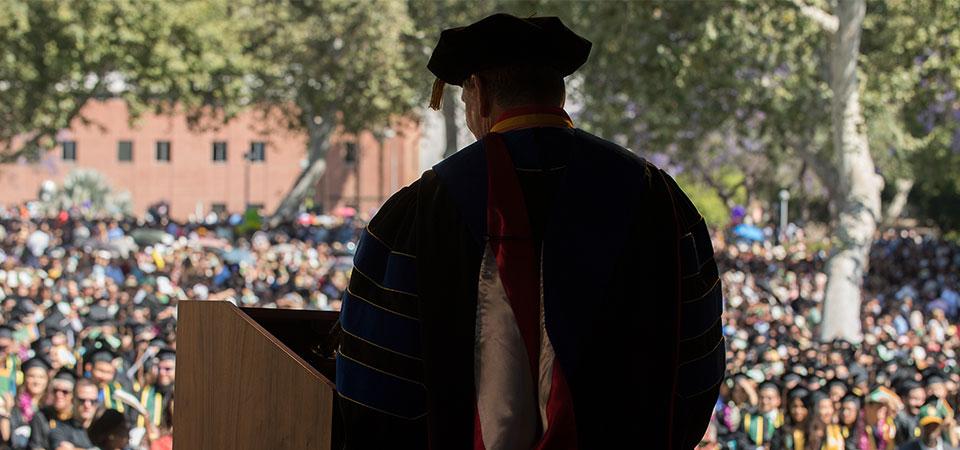 silhouette of dean at podium during Commencement  