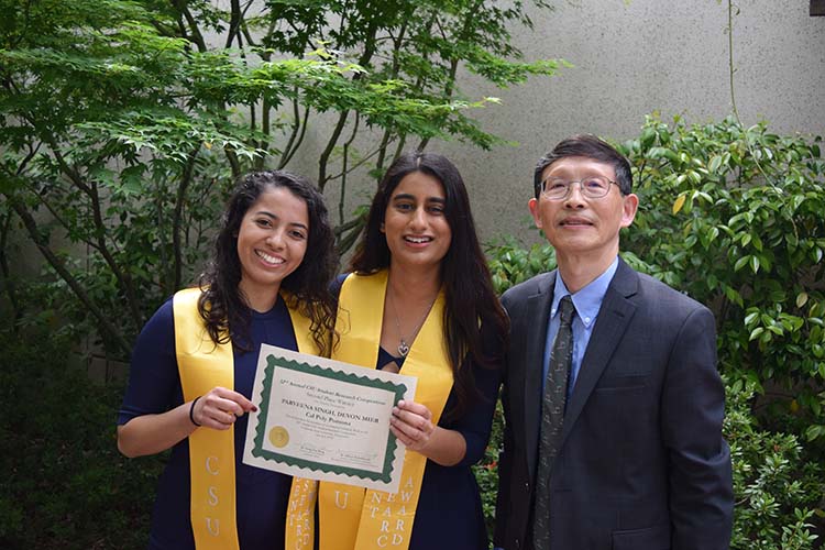 Devon Mier and Parveena Singh display their certificate; Dr. Paan stands with them