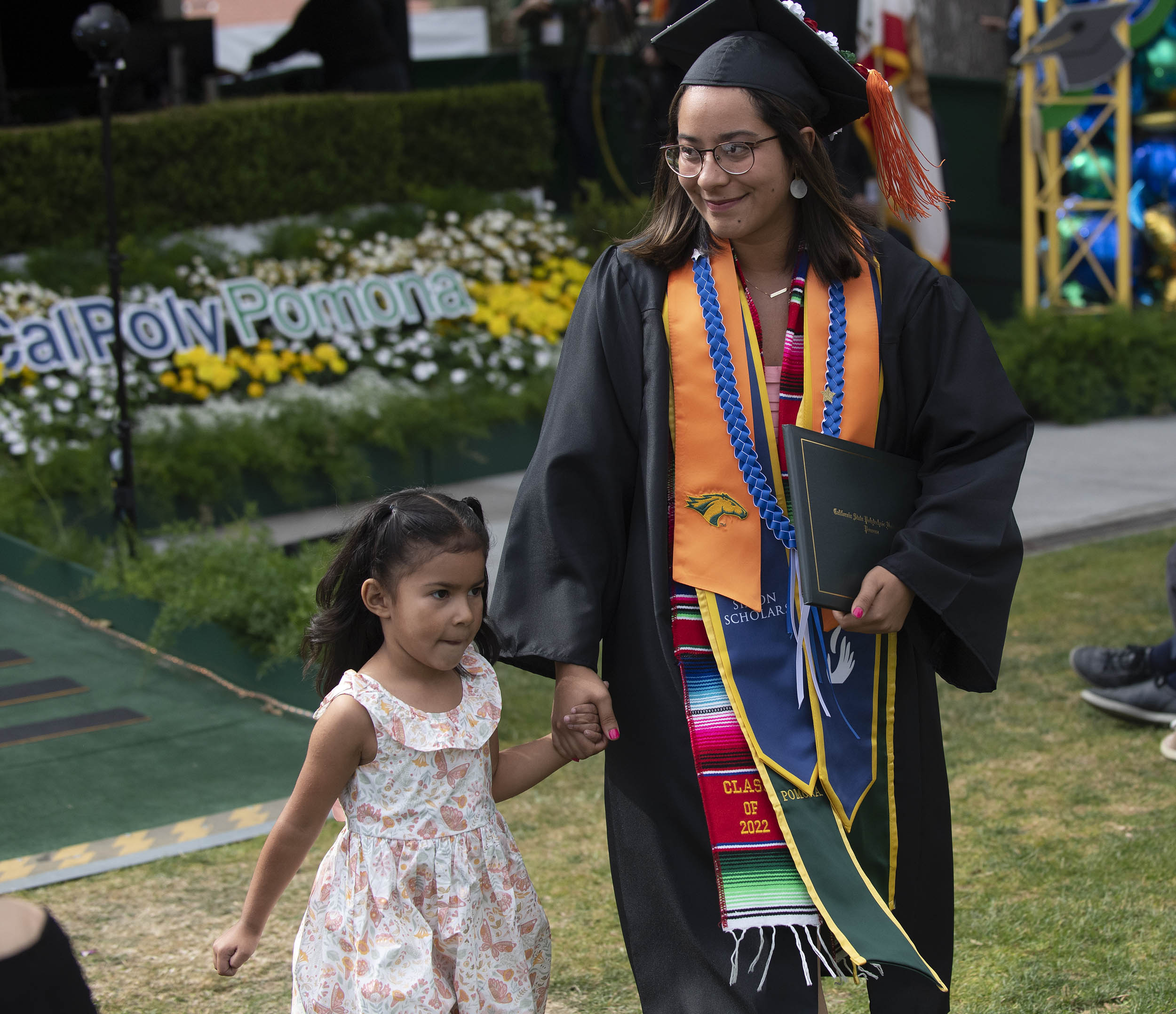 A graduate walking with her daughter
