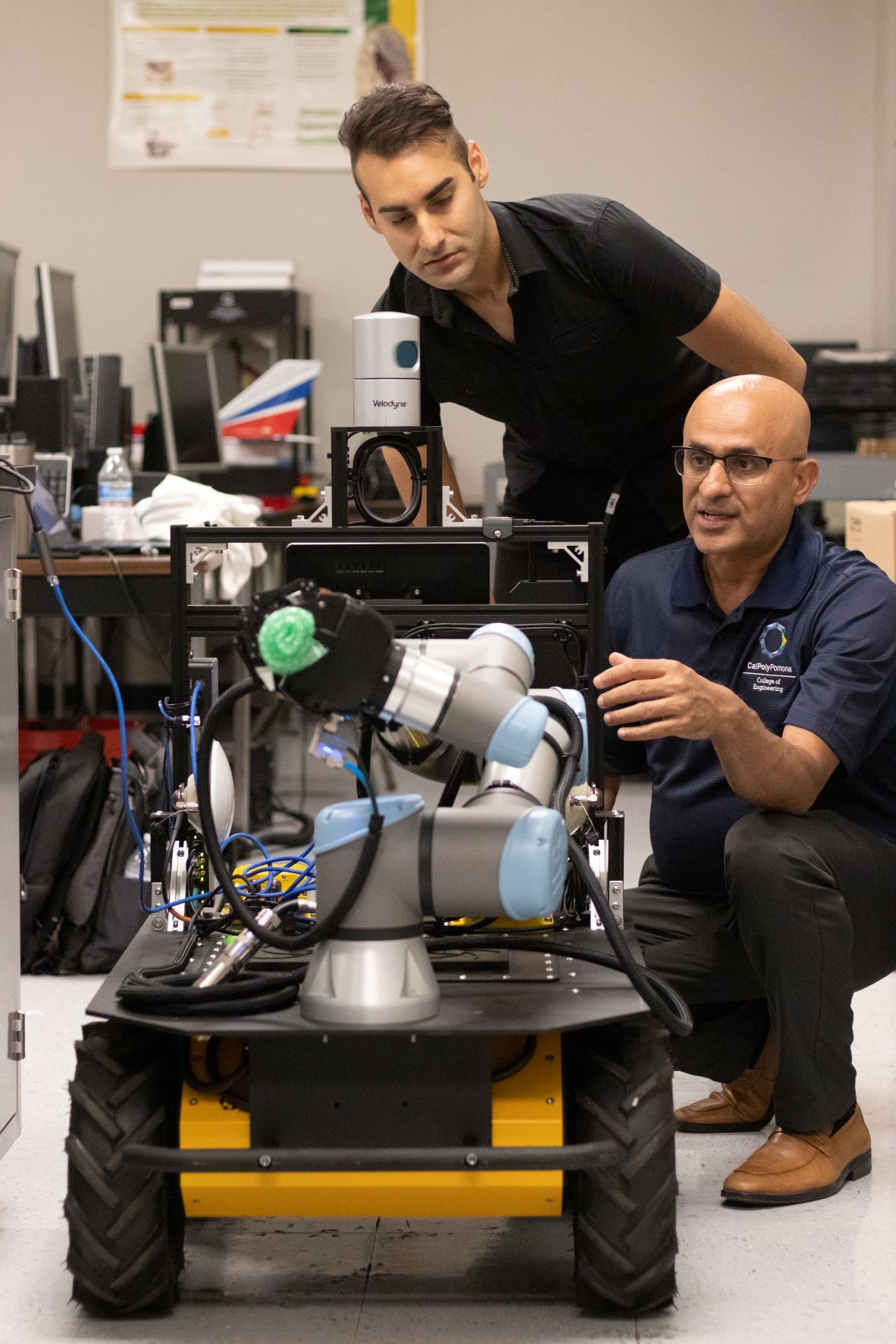 Professor Subodh Bhandari instructs an engineering student on using an unmanned ground vehicle.