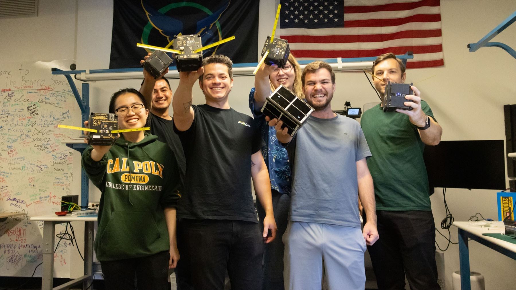 A group of Cal Poly Pomona engineering students holding out their CubeSats.