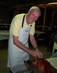 Bill Girouard carving a turkey at the IME Thanksgiving Feast