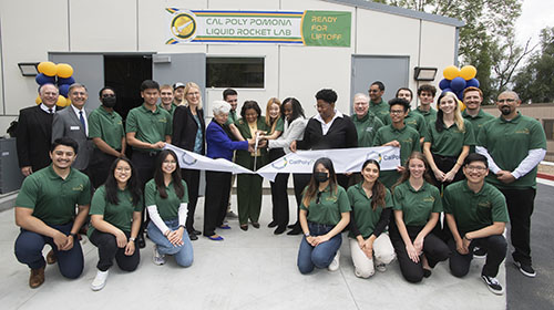 A group of university students, administrators and politicians at a ribbon-cutting ceremony.