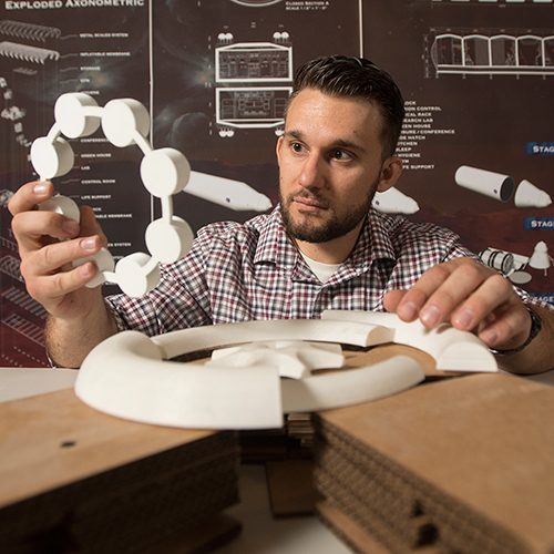 Laszlo Adrasi holds model of a Mars habitat 