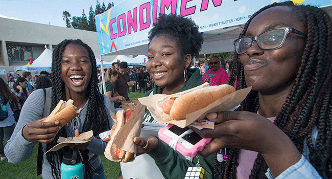 Three female students enjoy Hot Dogs during the 2019 Hot Dog Caper