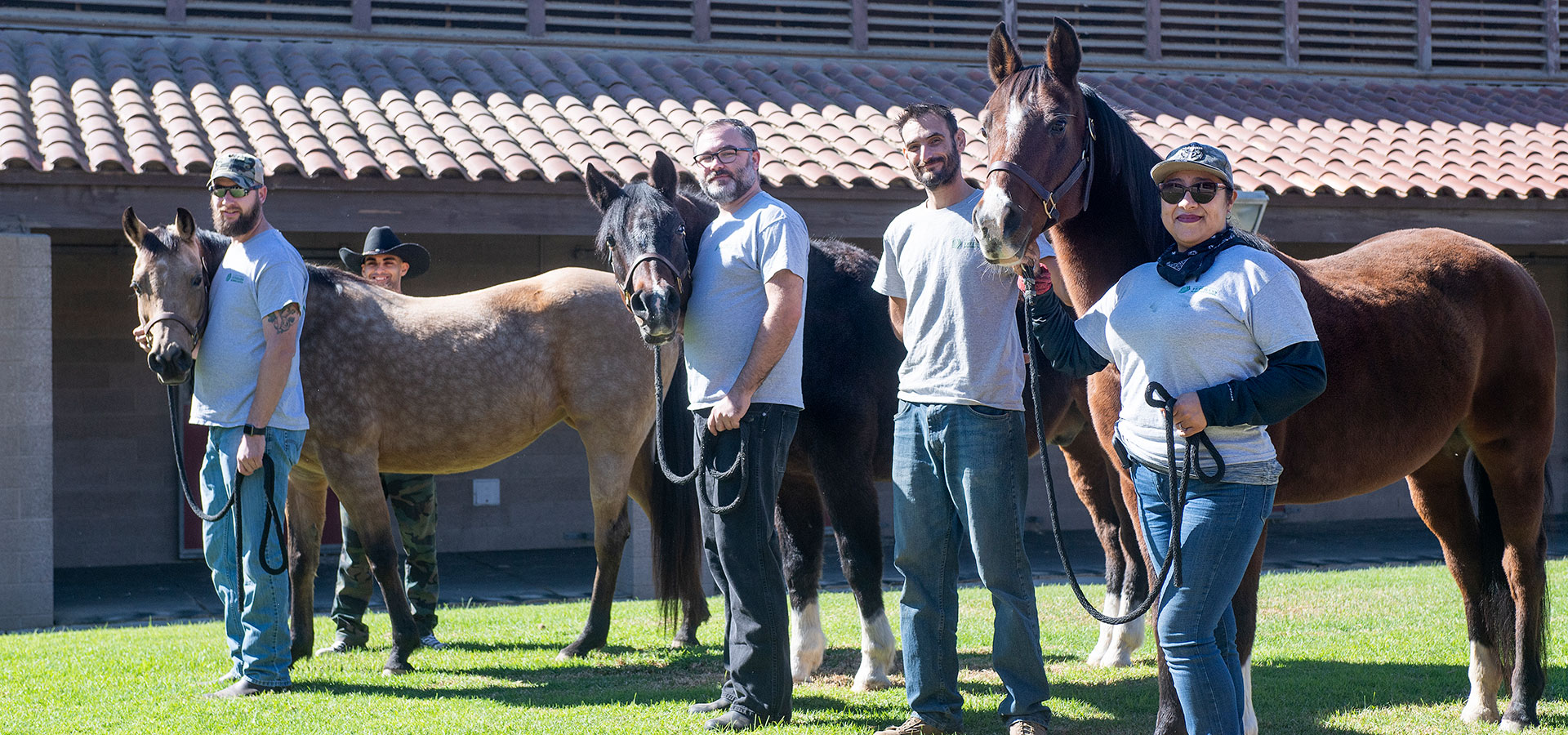 A group of veteran students pose with the Arabian horses in their care.
