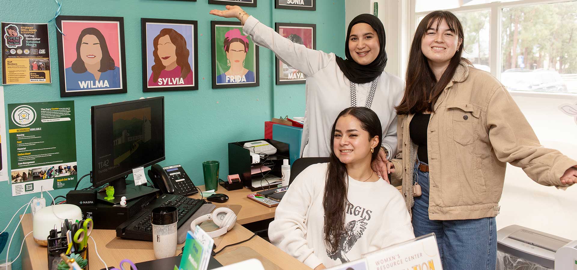 Three students pose for a photo in the Womxn's Resource Center.